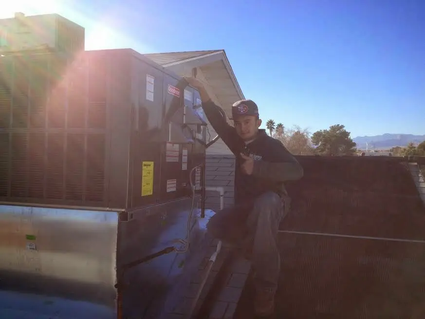 HVAC technician performing HVAC Inspection on a rooftop unit in Pingree Grove