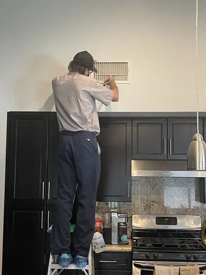 Technician inspecting an air vent during HVAC service in Pingree Grove